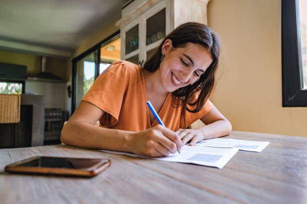 Beautiful woman is sitting at a desk and signing papers.