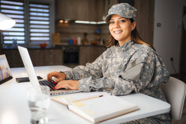 Portrait of a female soldier working on laptop at home