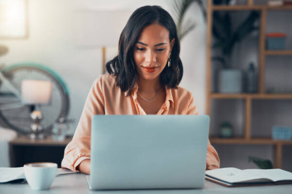 Woman working on a laptop at a desk.