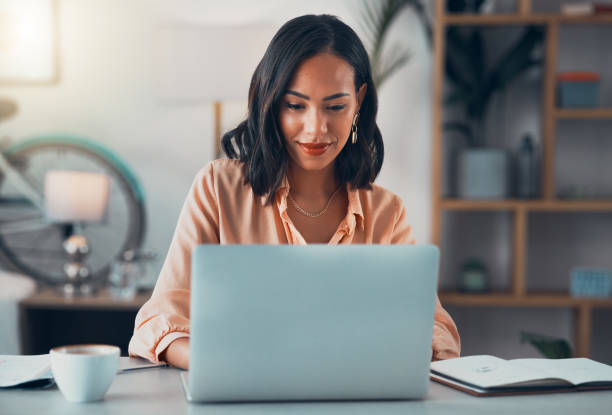 Woman working on a laptop at a desk.