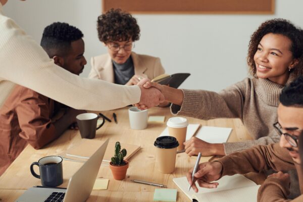 Group of diverse entrepreneurs meeting around a table, sharing ideas and collaborating in a bright workspace.”
