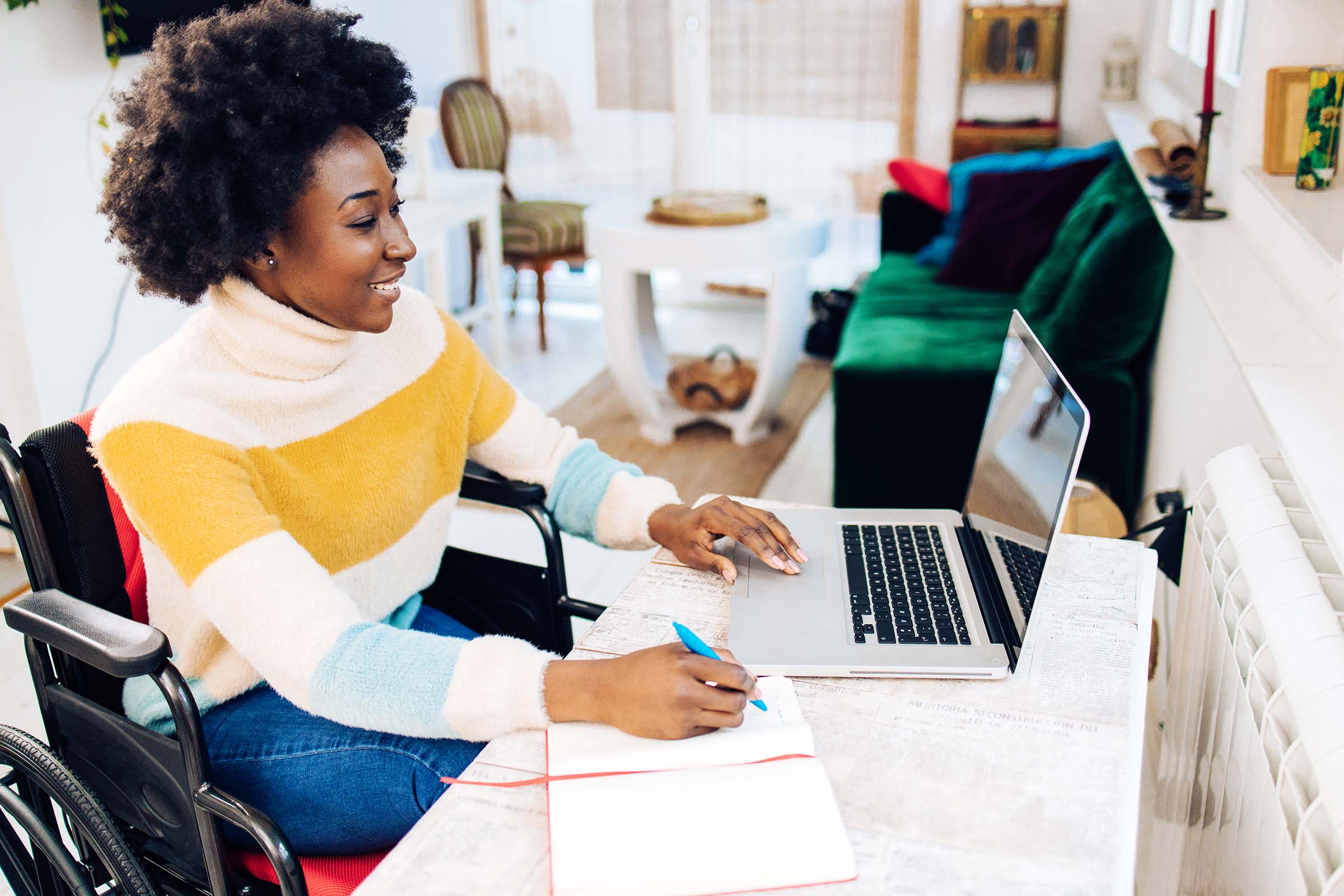 smiling black woman in wheelchair on laptop